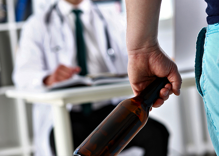 Patient holding a bottle while talking to his doctor